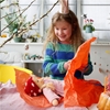 Une petite fille déballe son cadeau d'anniversaire: une poupée Nanchen vêtue d'une robe rose et d'un bonnet de laine rouge.